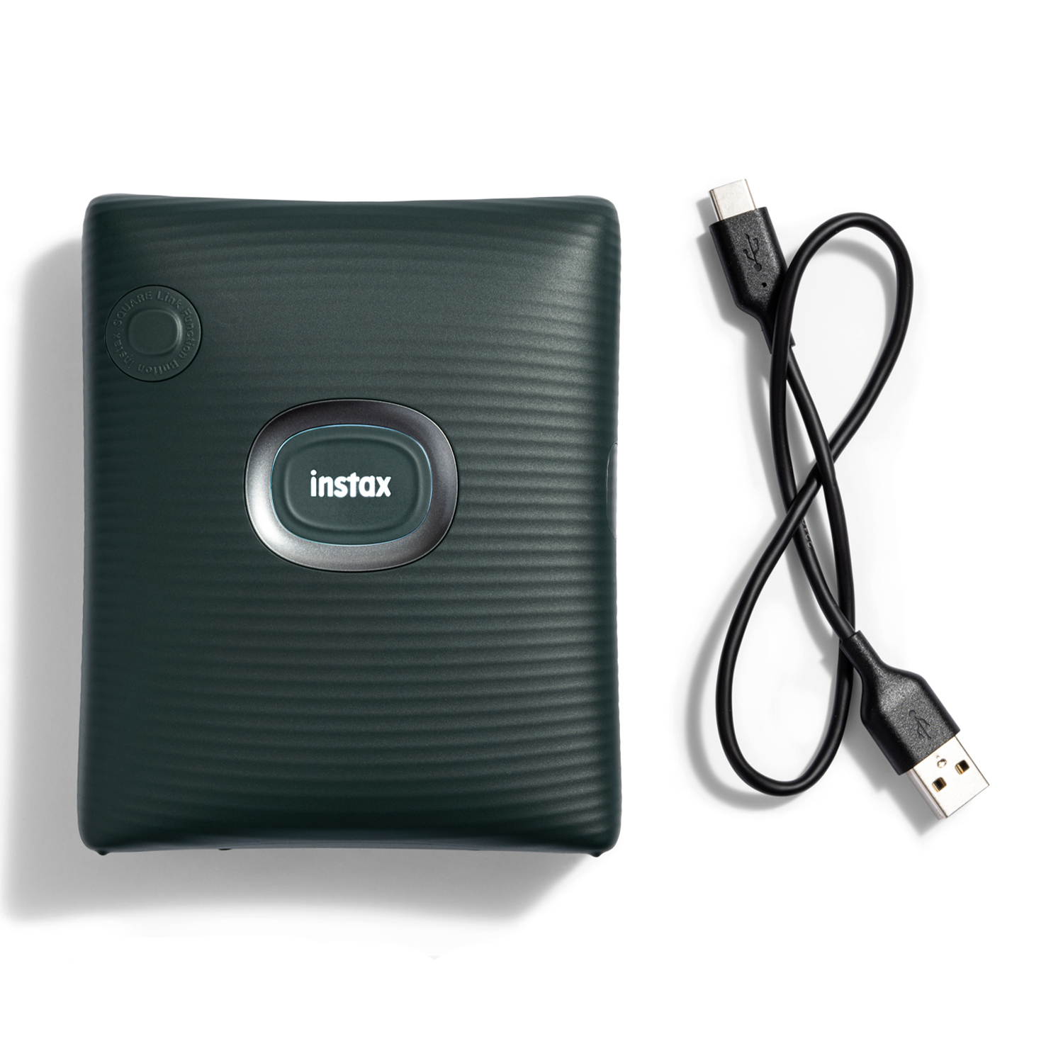 Stampante Instax verde scuro con cavo USB su sfondo bianco.