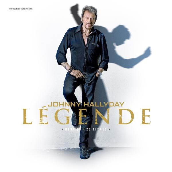 Albumhoes van Johnny Hallyday. Man in donker overhemd en jeans, leunend tegen een witte muur. Titel 'Legende'.