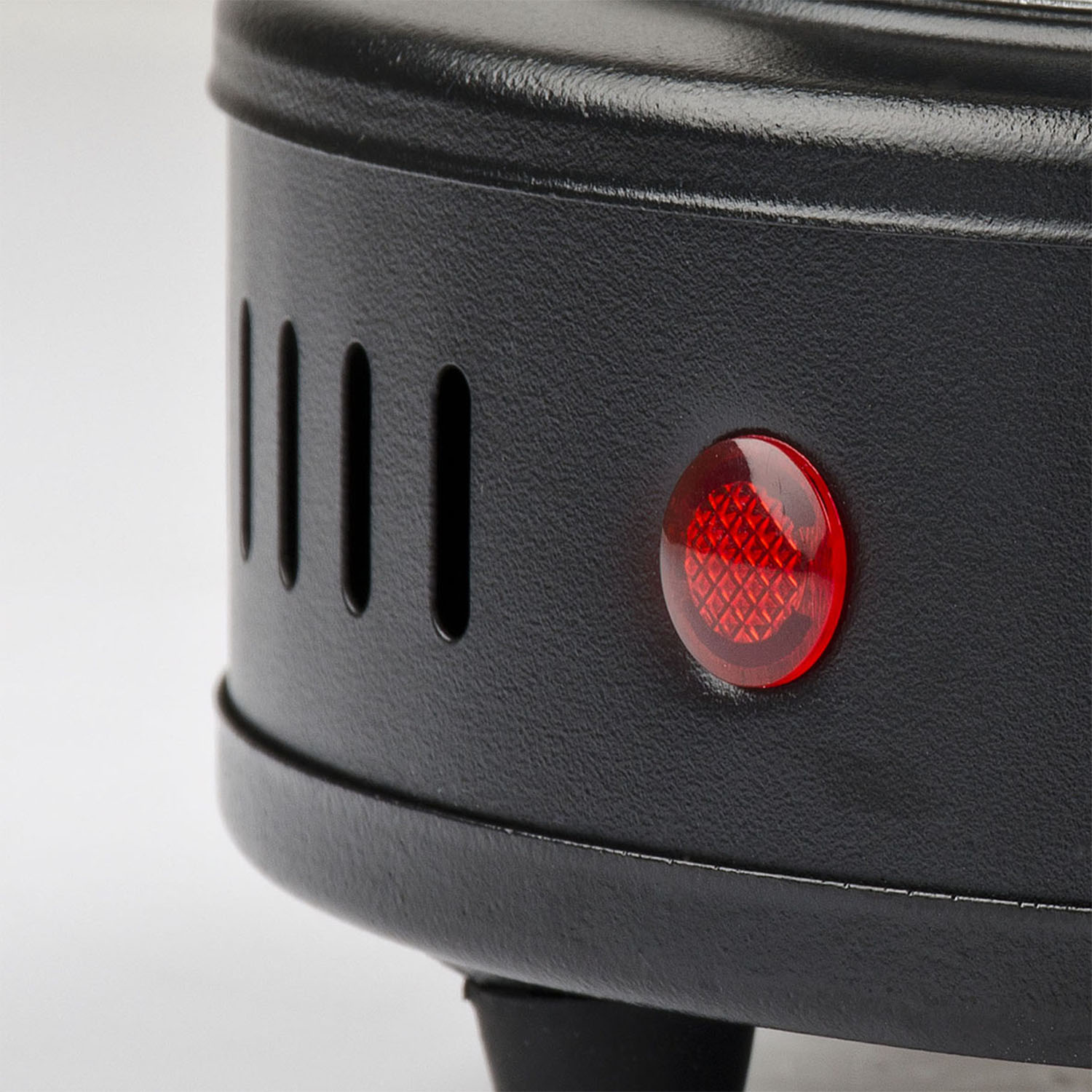 Un primo piano di un elettrodomestico in metallo nero con una luce rossa, che indica che è acceso.