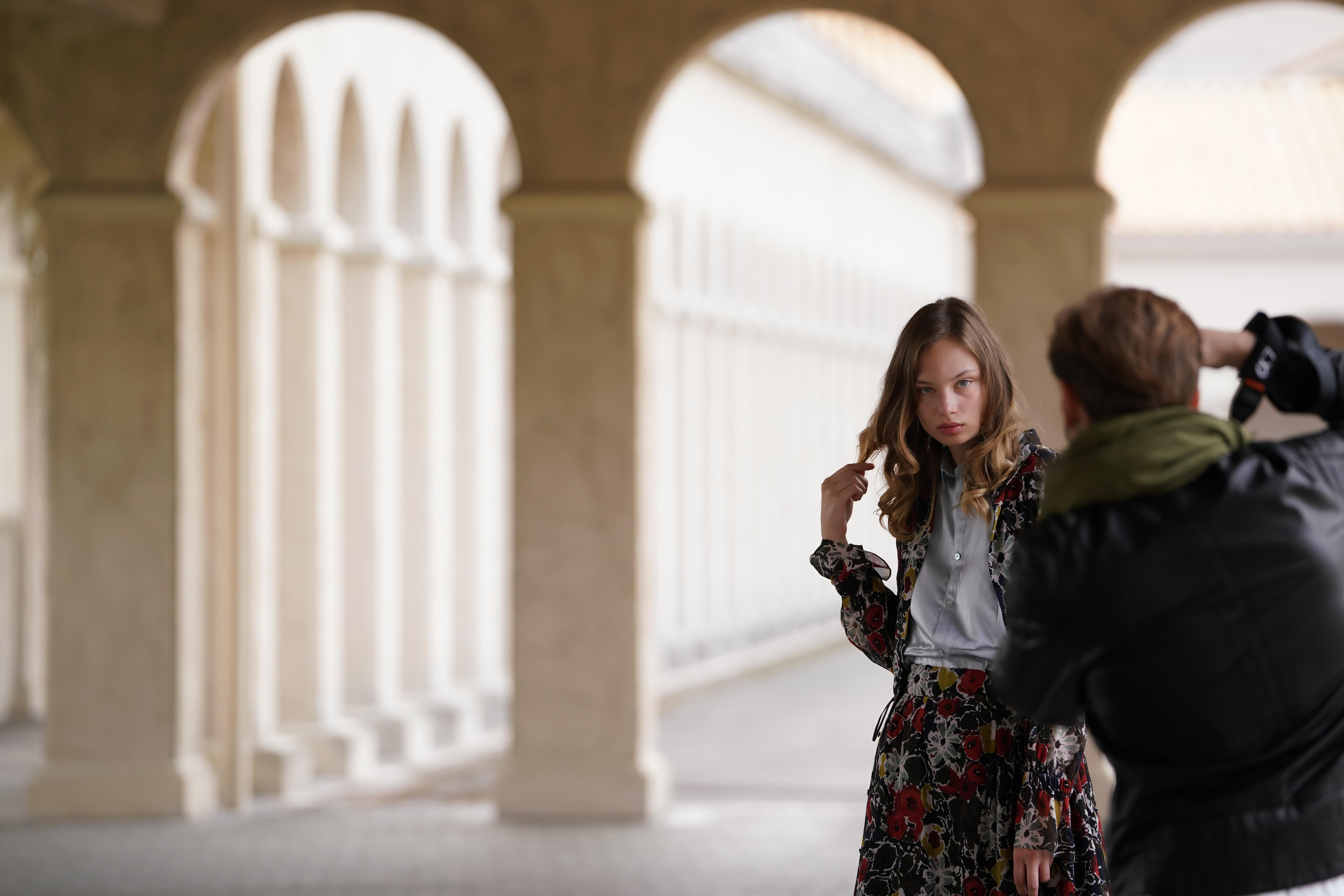 Model wird von einem Fotografen in einer architektonischen Umgebung fotografiert.