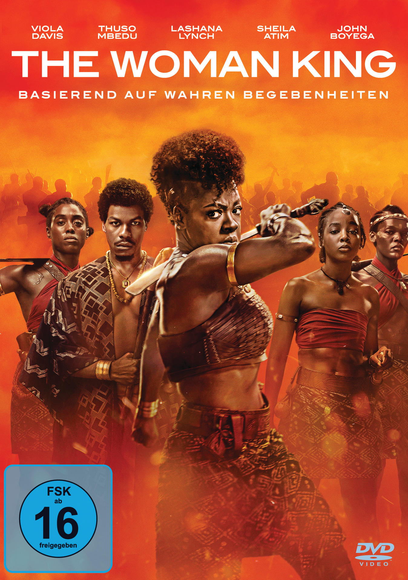 Filmplakat: The Woman King. Frauen mit Waffen, Action-Pose. Oranger Hintergrund.