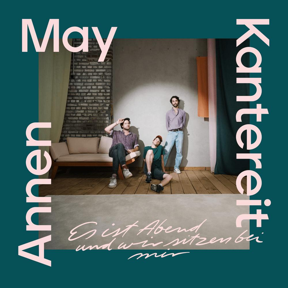 Albumcover: Drei Männer in einem Raum, Text May, AnnenMayKantereit, teal Rahmen.