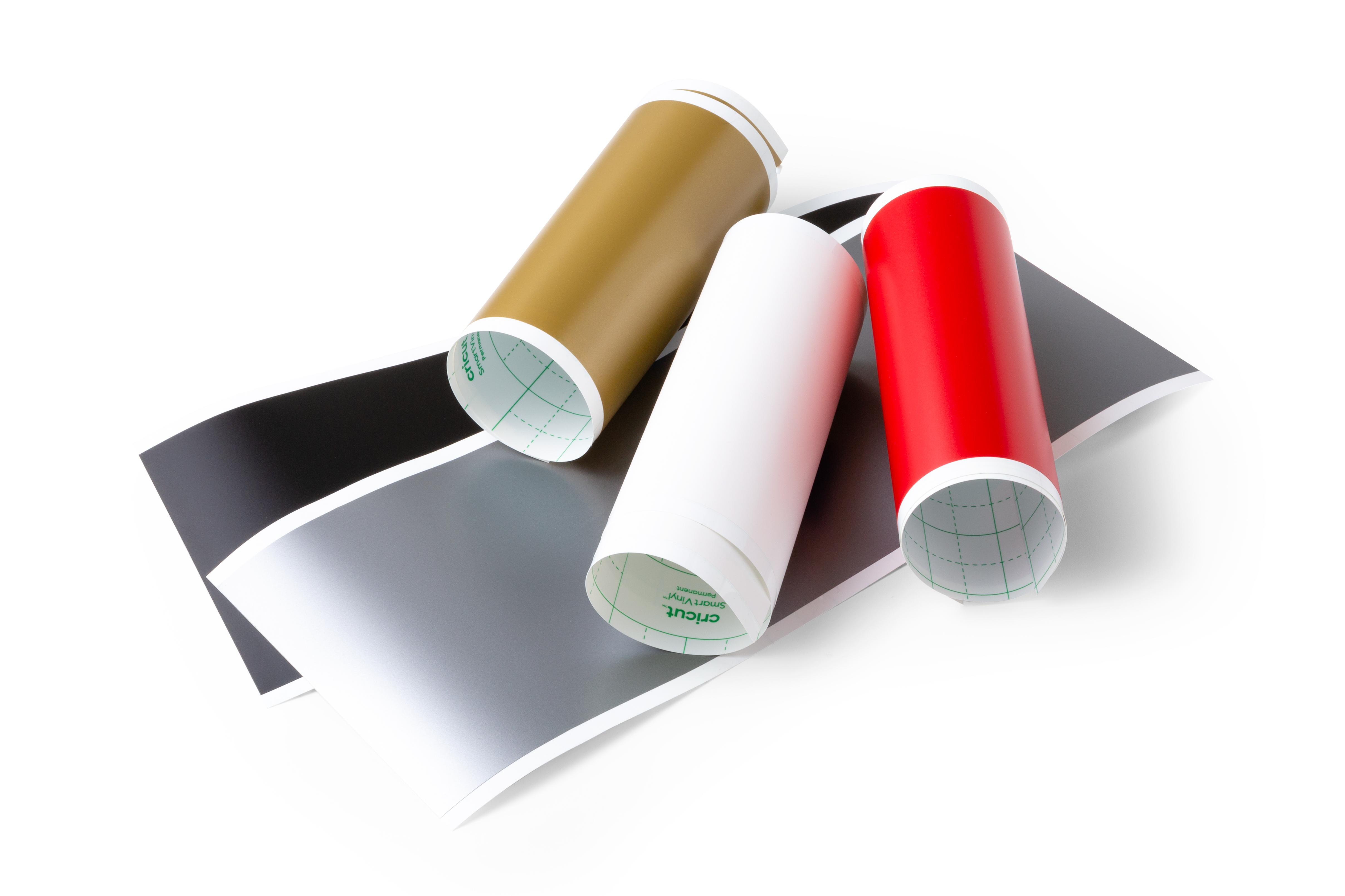 Drei Rollen Vinylfolien in verschiedenen Farben: Gold, Weiß und Rot. Schwarze und graue Folien darunter.
