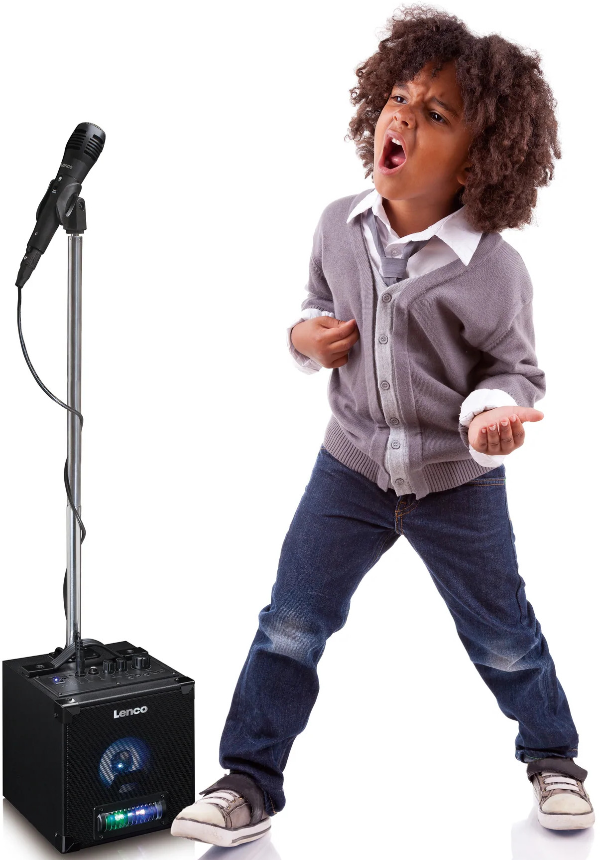 Jeune garçon chantant dans un microphone. Haut-parleur noir à gauche. Fond blanc.