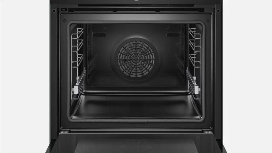 Intérieur noir du four avec grilles et ventilateur.