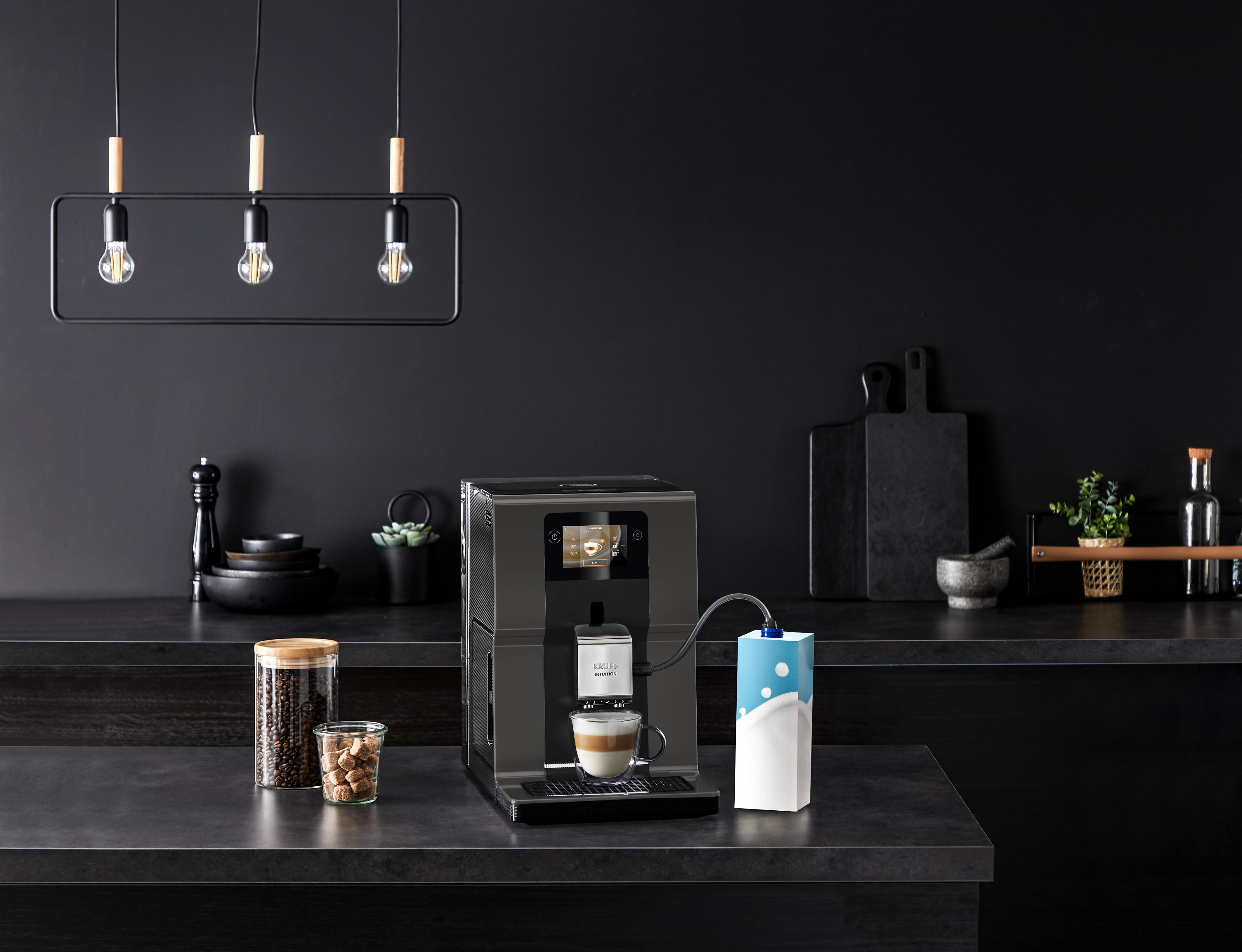 Kitchen with a coffee machine. Coffee is pouring into a cup. Dark background.