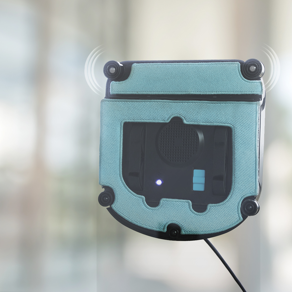 Robot de limpieza de ventanas en una ventana de vidrio. Tiene un marco azul y partes negras.