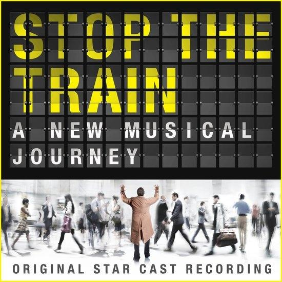 Flip-Disc tábla szerint: 'STOP THE TRAIN A NEW MUSICAL JOURNEY'. Emberek sétálnak lent.