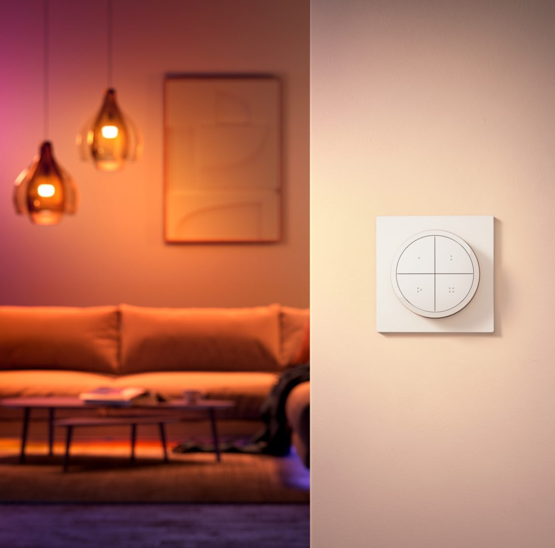 Un mur blanc avec un panneau de contrôle de maison intelligente et un salon en arrière-plan.