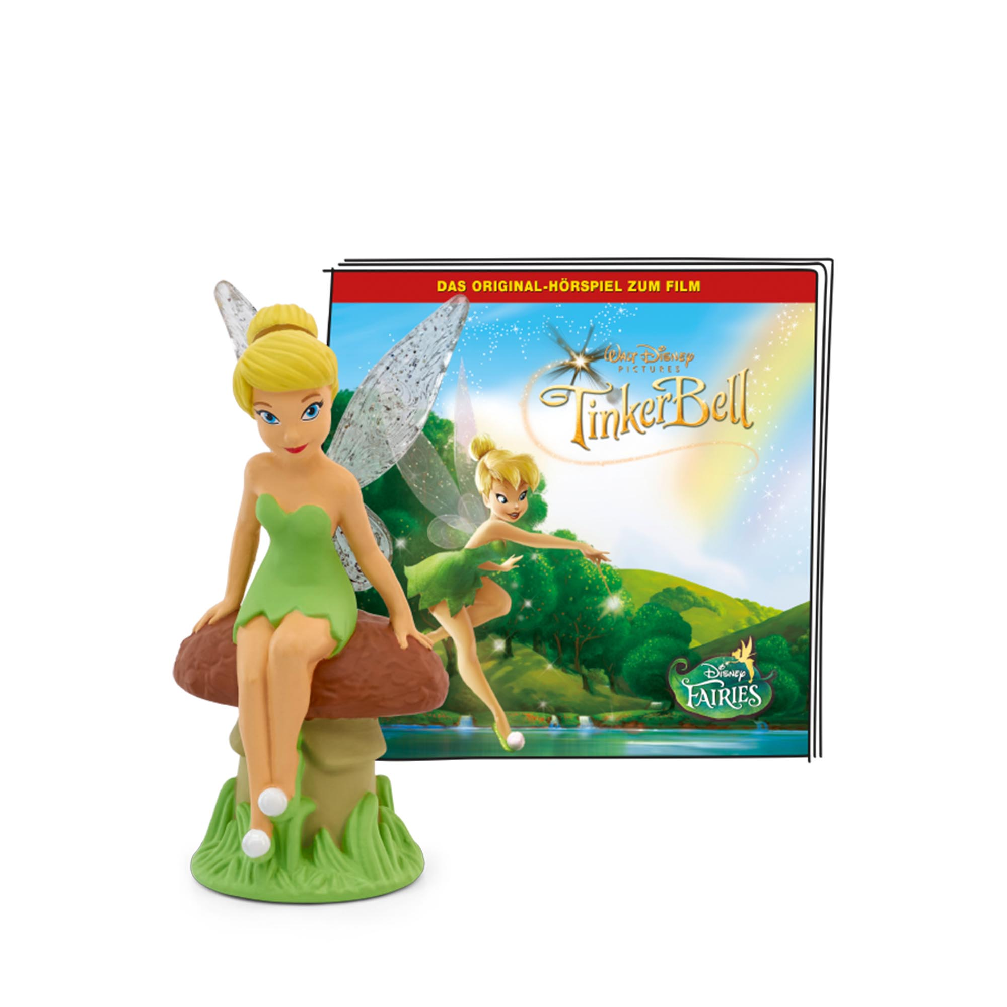 Tinkerbell-Figur sitzt auf einem Pilz, mit einem Buchcover von Tinkerbell und einer Fee im Wald.