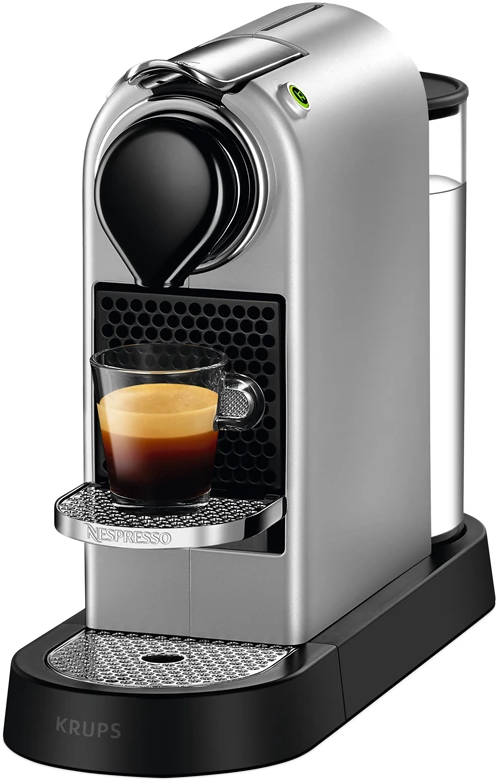 Ezüst Nespresso kávéfőző egy csésze eszpresszóval. Fekete alappal és átlátszó víztartállyal rendelkezik.