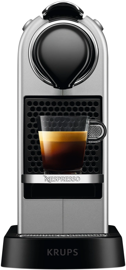 Ezüst-fekete Nespresso kávéfőző egy pohár kávéval.