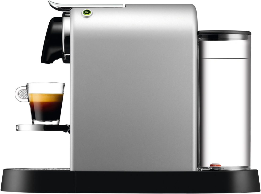 Egy ezüst Nespresso kávéfőző. Van rajta egy csésze kávé egy kis tálcán, egy víztartállyal az oldalán.