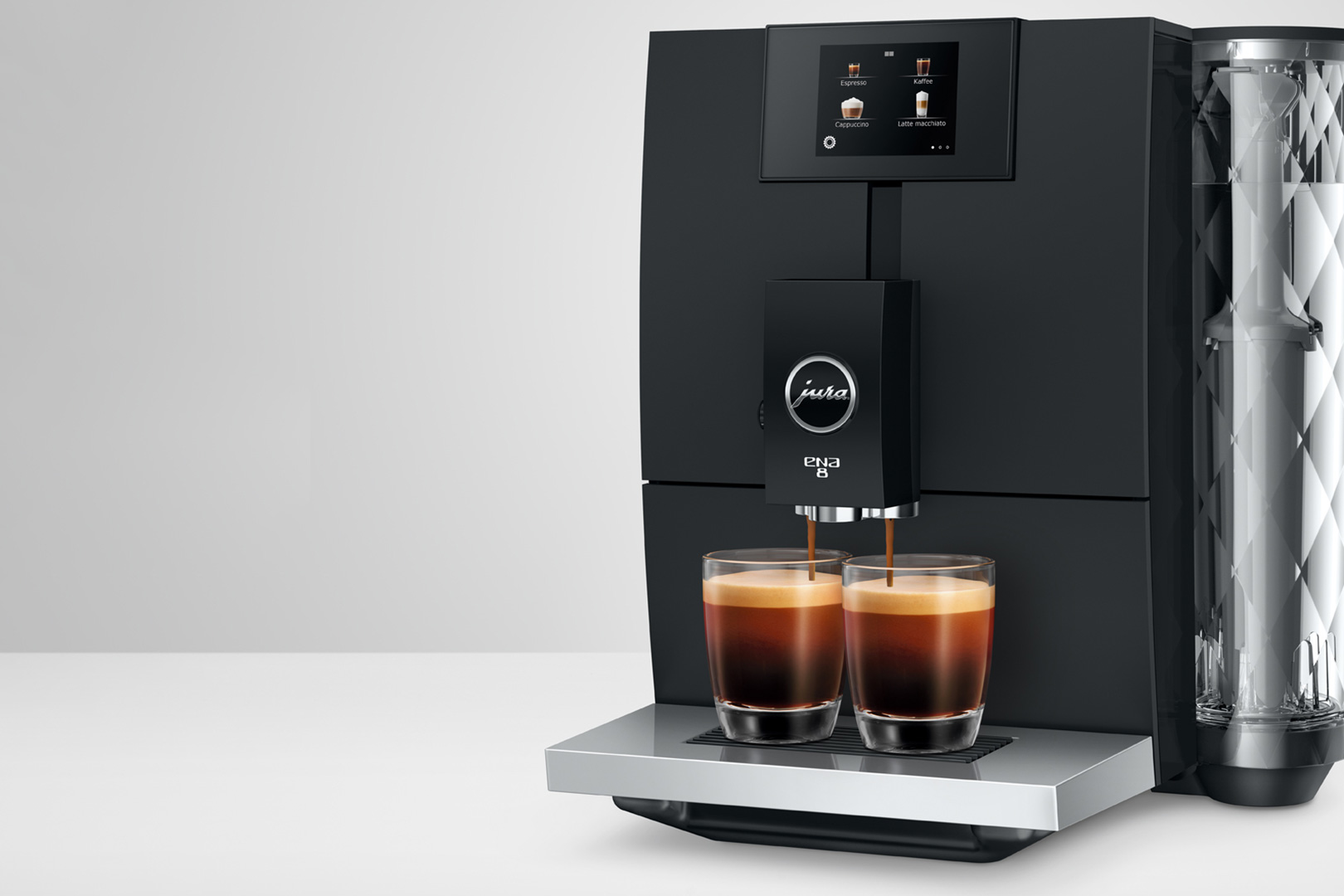 Macchina da caffè nera con due bicchieri che si riempiono di espresso, testo sullo schermo.