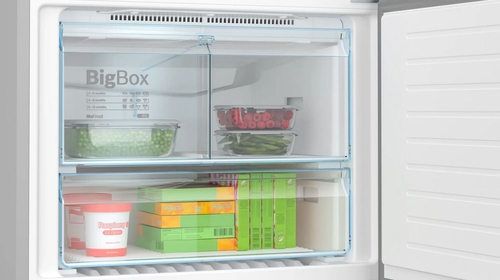 Interior de refrigerador con estantes. Contiene guisantes, frambuesas y otros alimentos congelados.