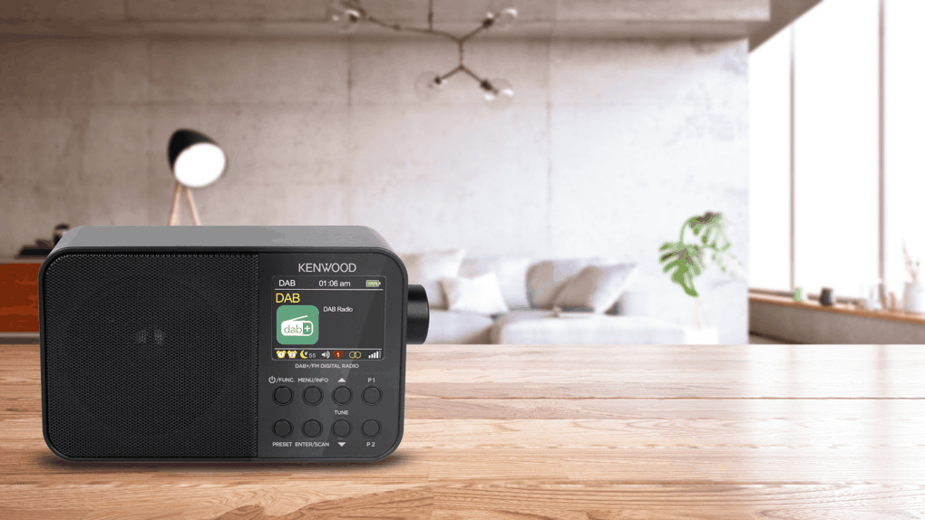 Zwarte Kenwood DAB-radio op houten tafel, met vage achtergrond van woonkamer.