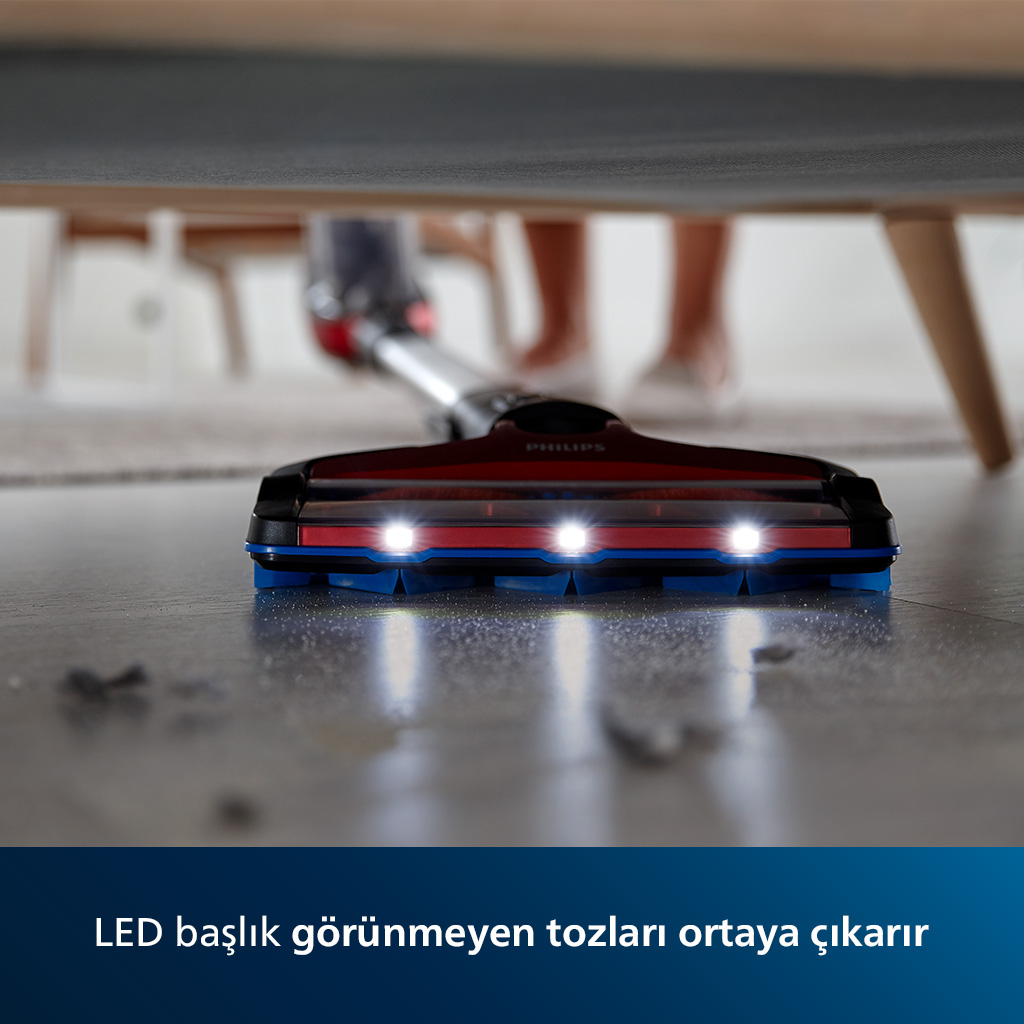 Bir zemini temizleyen elektrik süpürgesi başlığı. Metin, LED ışıkların gizli tozu ortaya çıkardığını belirtir.