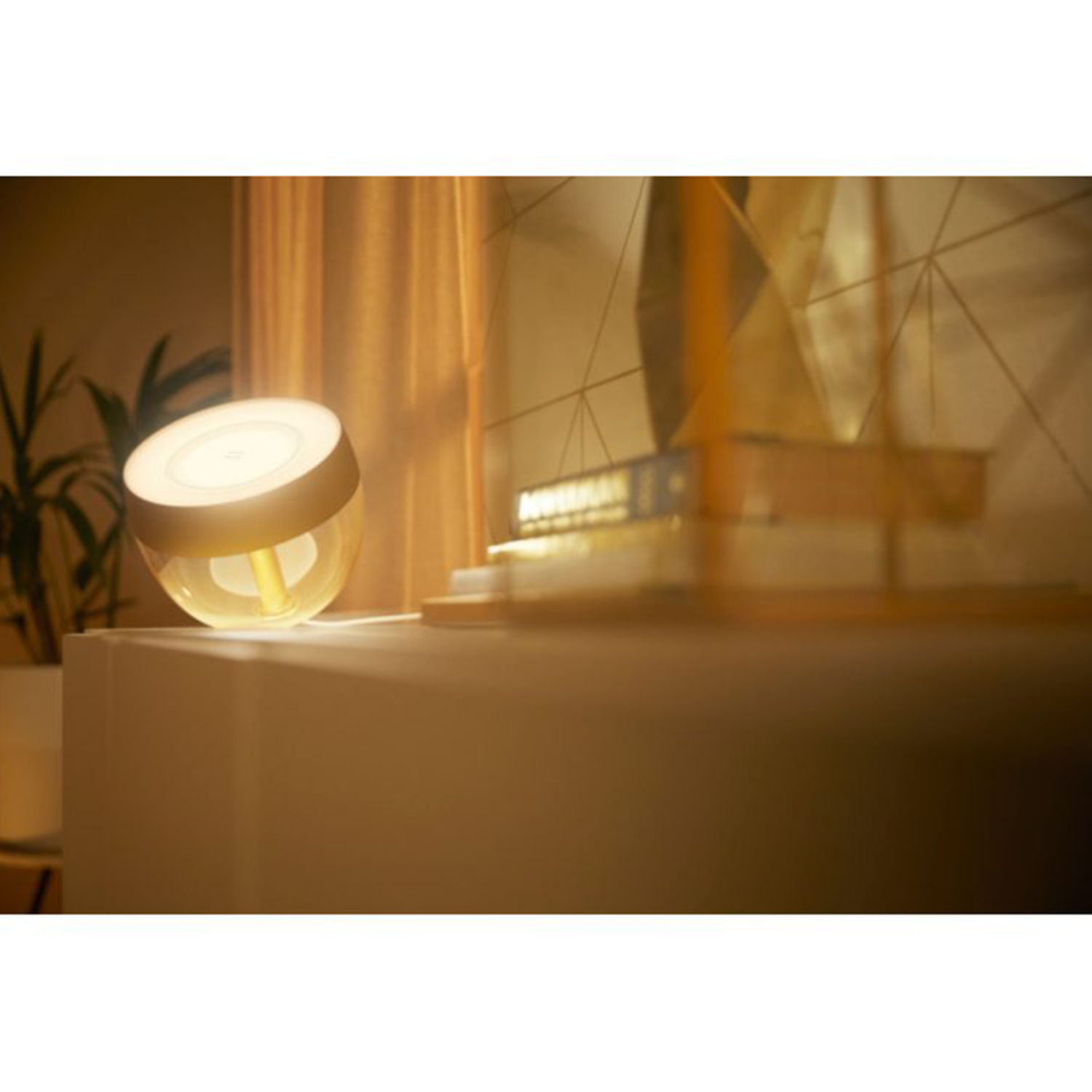 Una lampada da tavolo dalla forma arrotondata e con base dorata è su un tavolo.