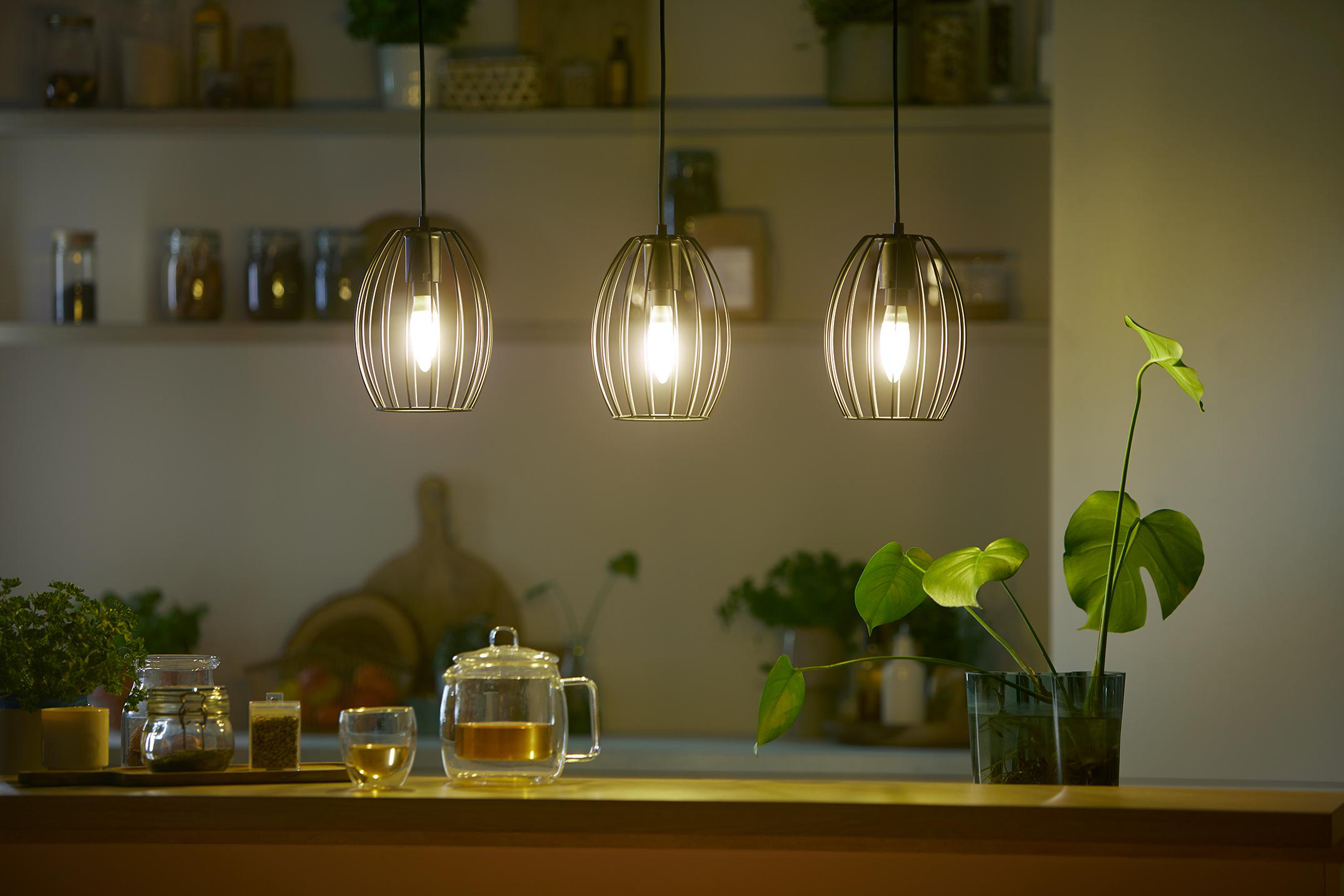Drei Hängelampen über einer Küchentheke mit Dekoration.