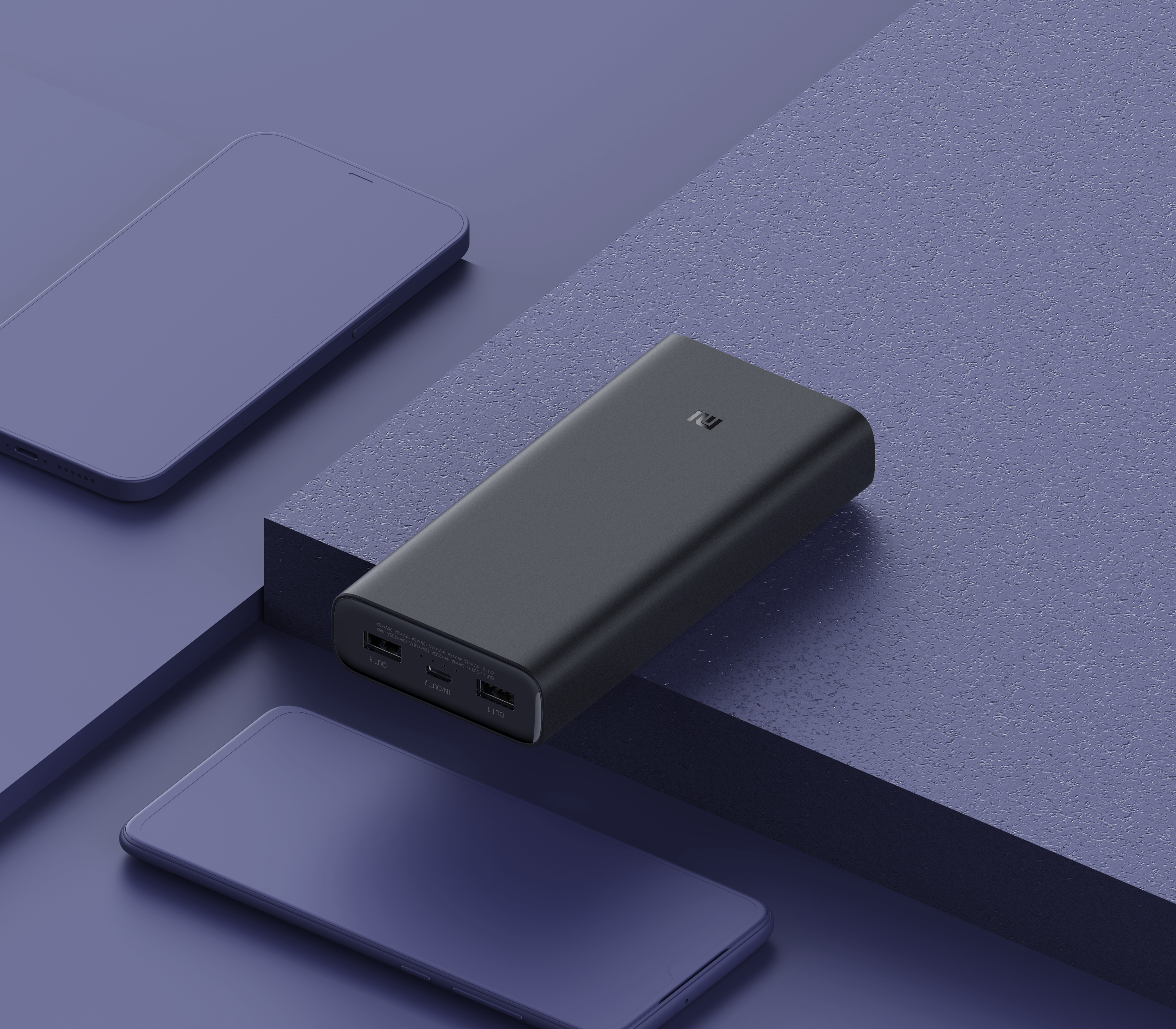 Power bank nera e due telefoni su una superficie blu. Il power bank ha un logo.