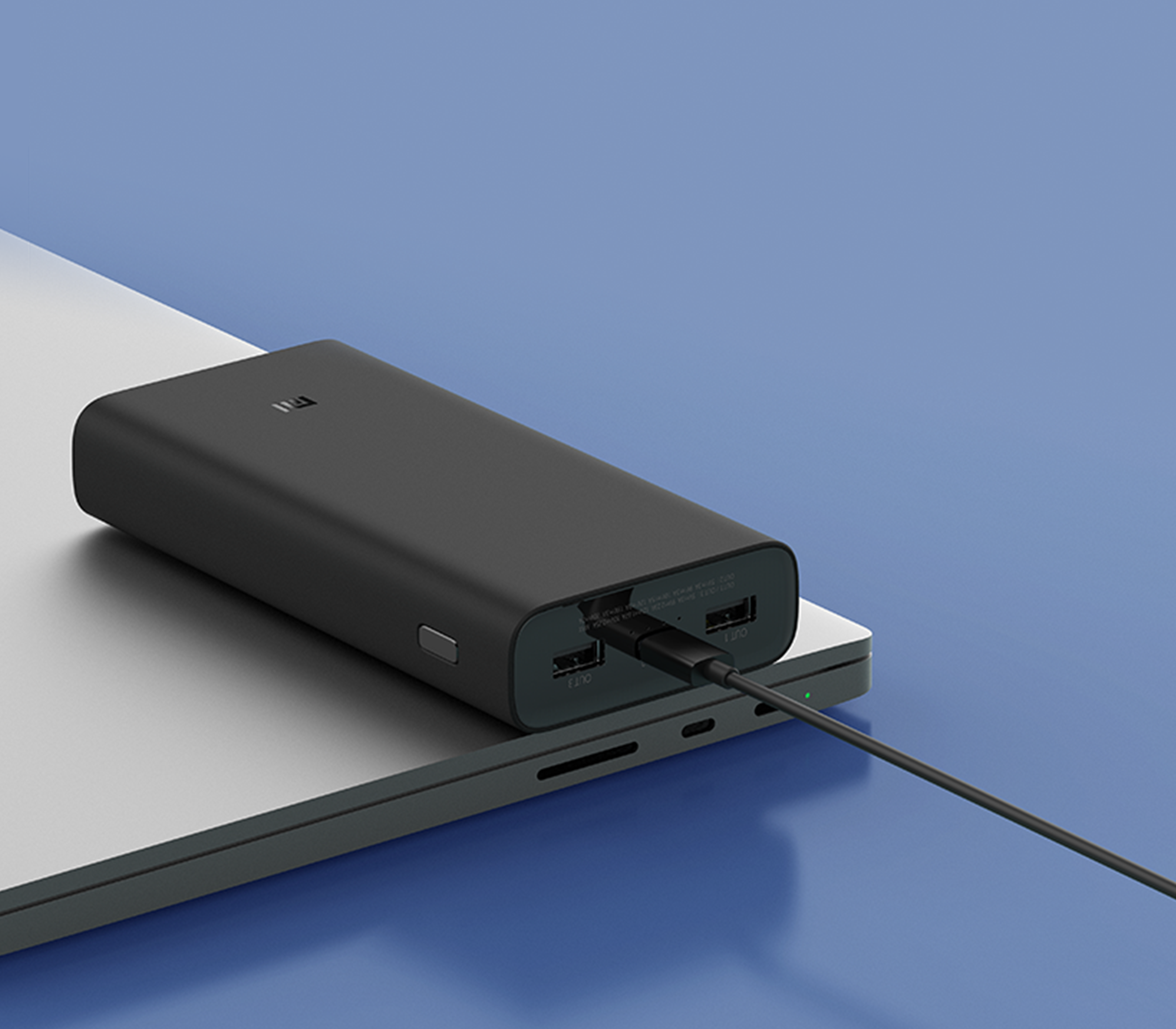 Power bank nero su un laptop. Un cavo collegato. Laptop argentato.