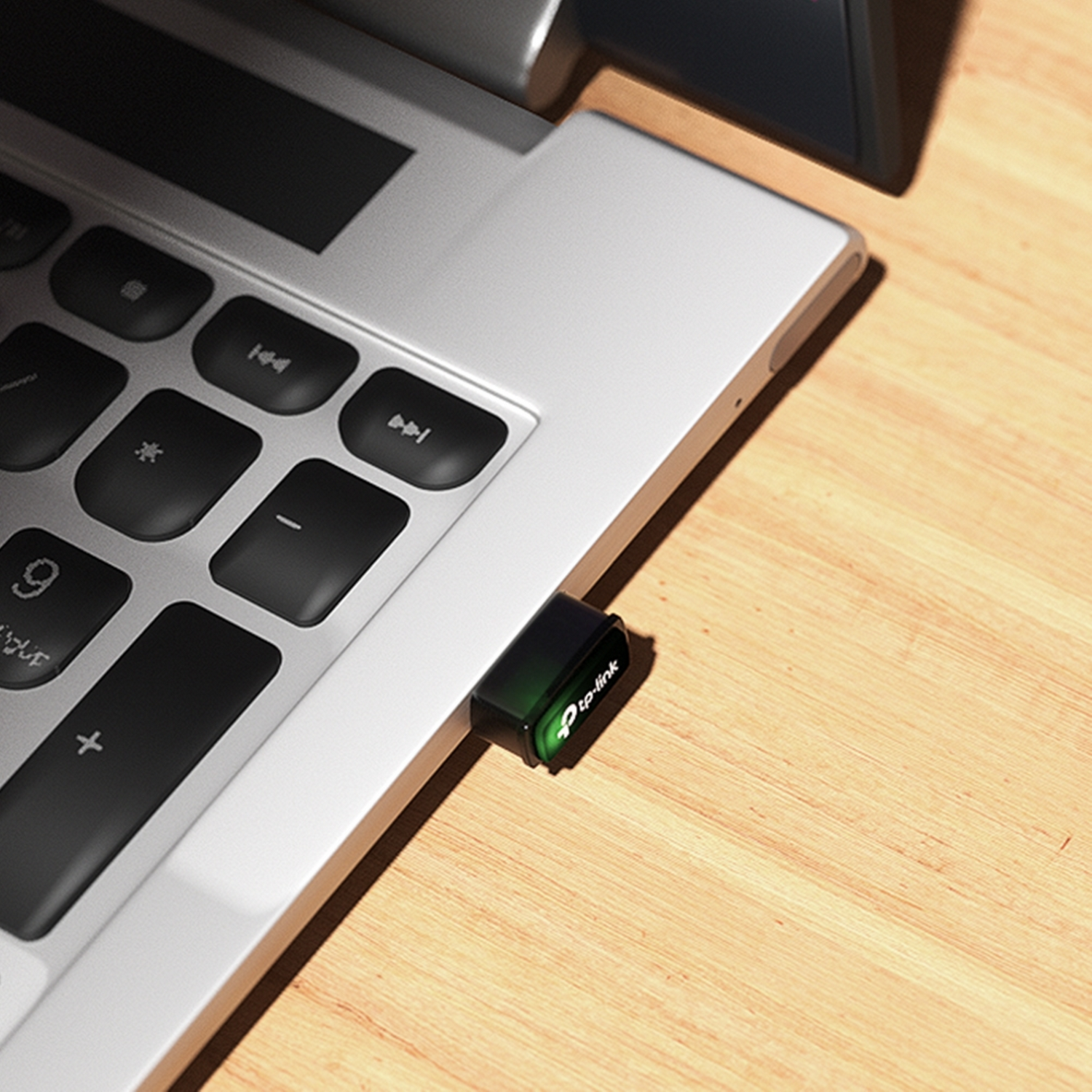 Laptop with a USB wifi adapter plugged in. Wood table background.