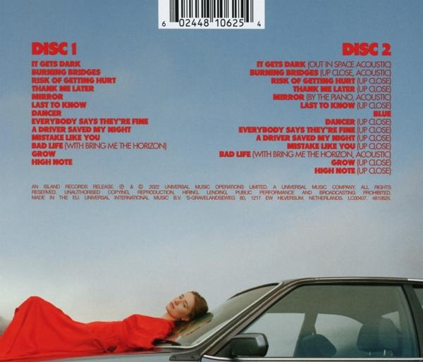 Rückseite einer Musik-CD mit Titellisten und einer Frau in Rot, die sich an ein Auto lehnt.