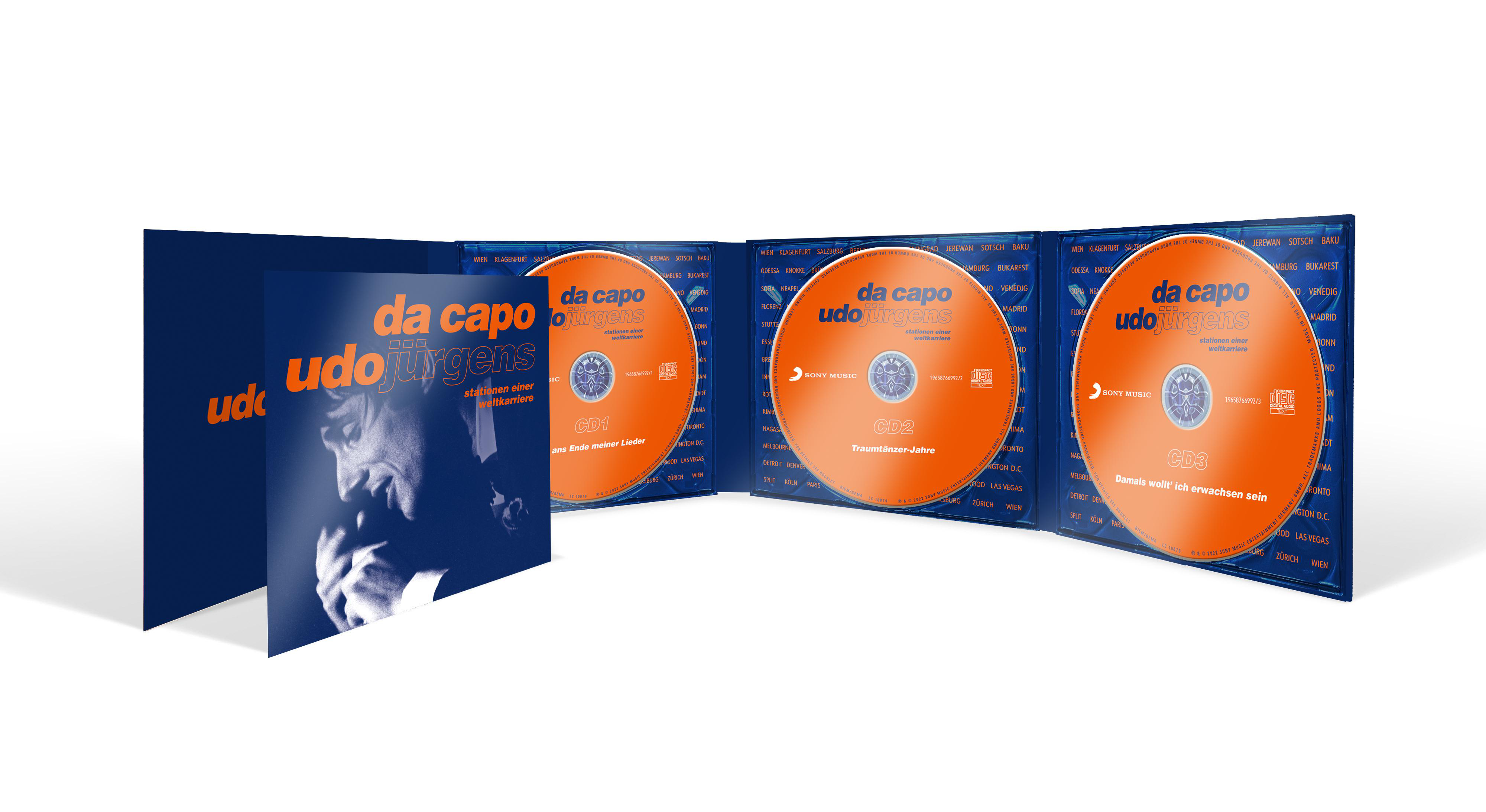 Geöffnete CD-Hülle mit drei orangefarbenen CDs. Udo Jürgens' Album 'Da Capo'.