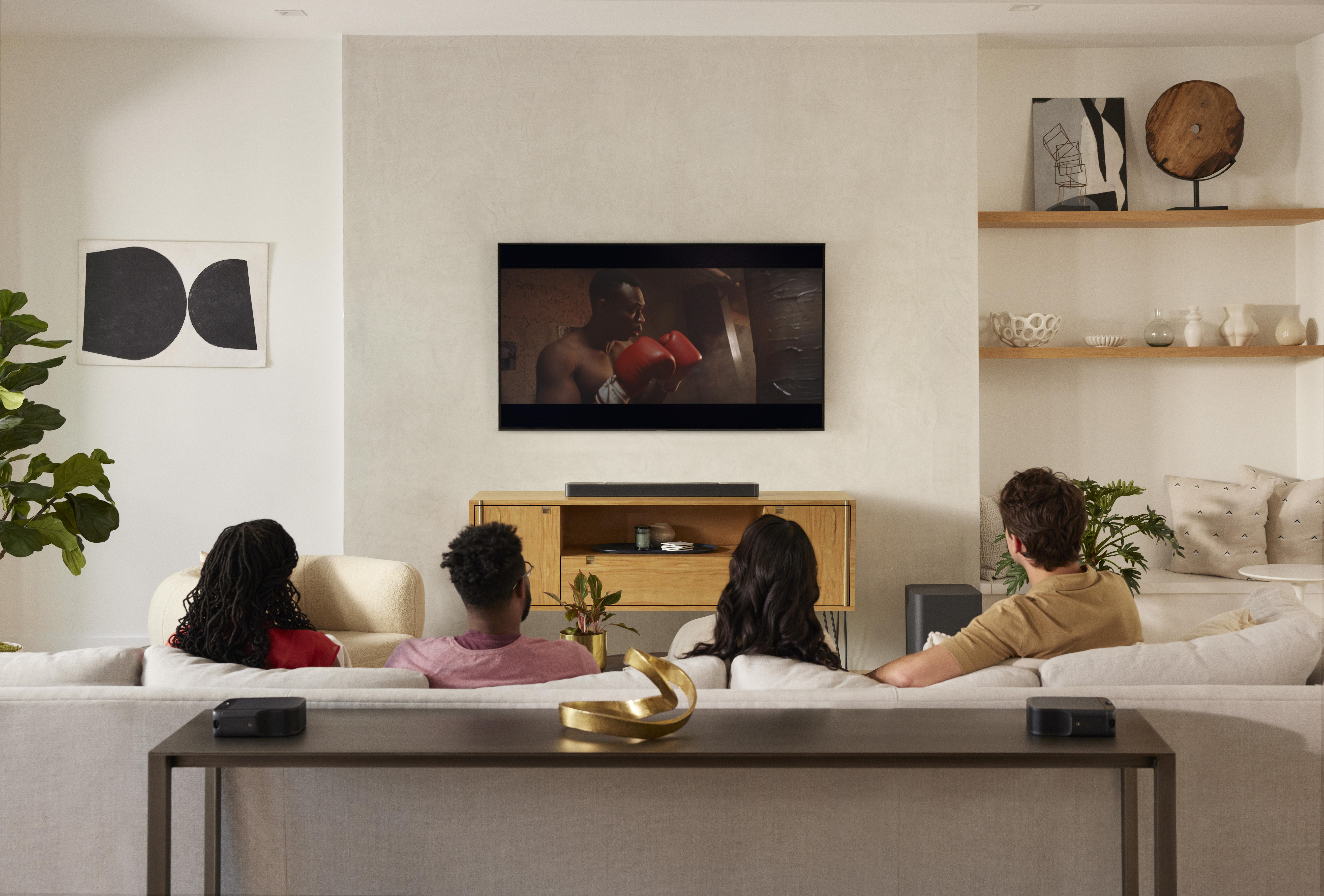 Gruppe von Leuten, die fernsehen, mit einem Boxer auf dem Bildschirm. Modernes Wohnzimmer.