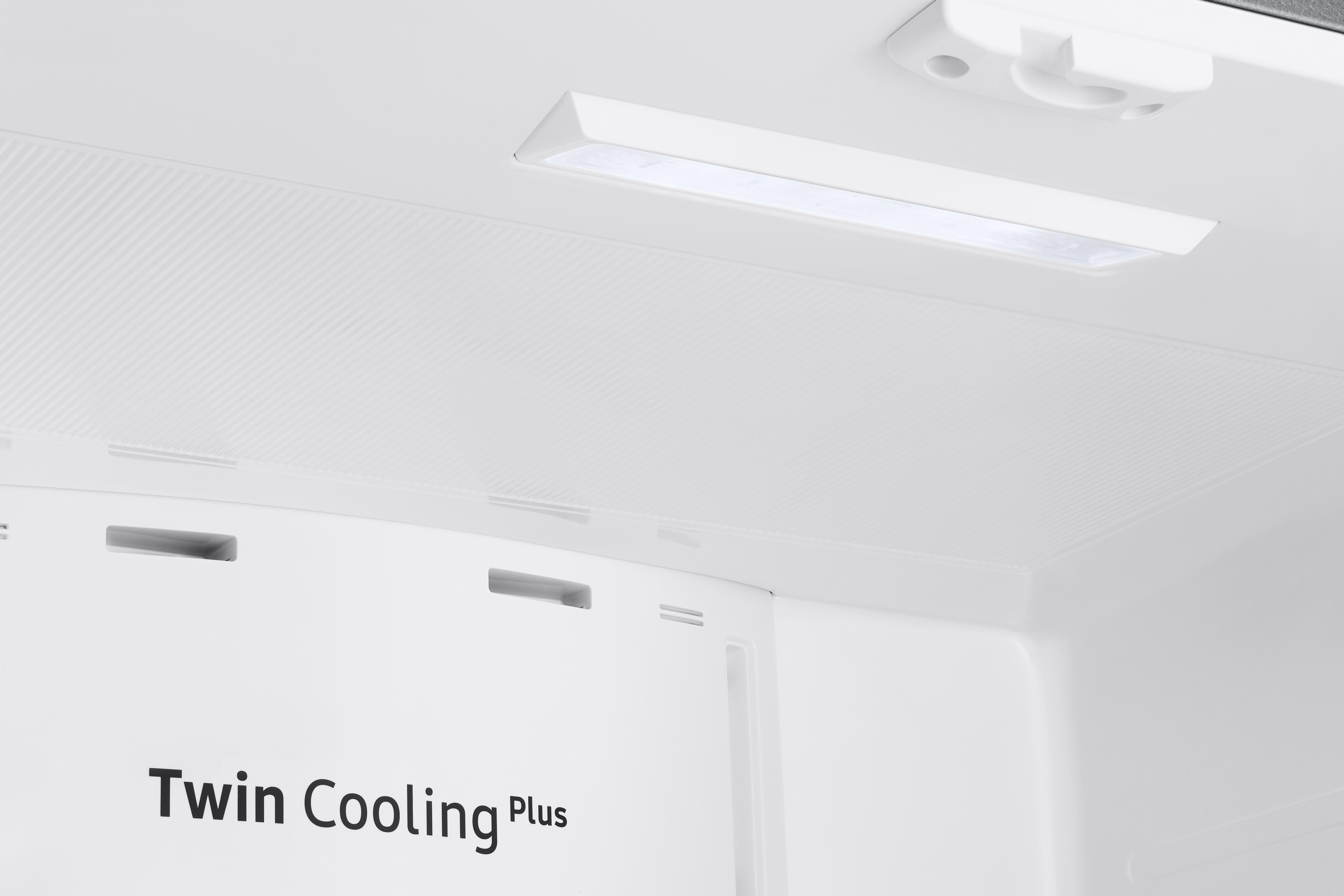 Weißer Innenraum eines Kühlschranks, mit einer Leuchte oben und dem Schriftzug 'Twin Cooling Plus'.