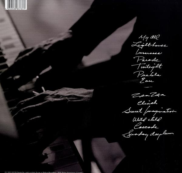 Gros plan sur des mains jouant du piano, avec des titres de chansons.