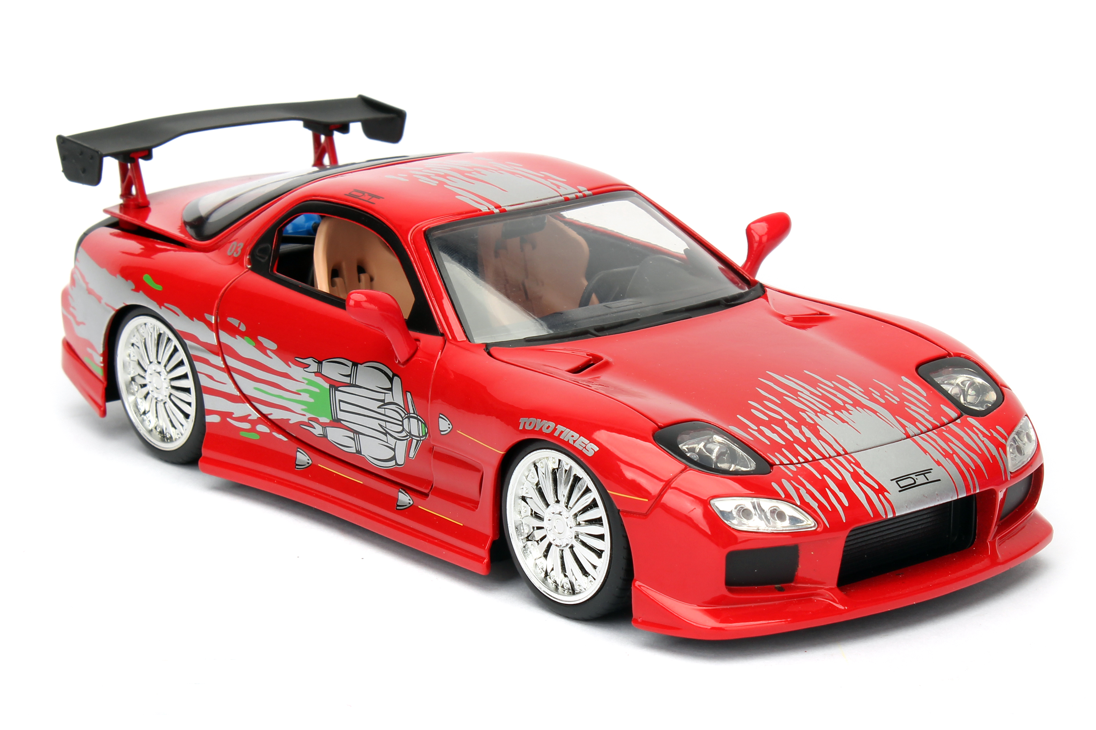 Rotes Spielzeugauto mit silbernen Akzenten, schwarzem Spoiler und Chromrädern. Es hat 'TOYO TIRES' an der Seite und einen weißen Hintergrund.