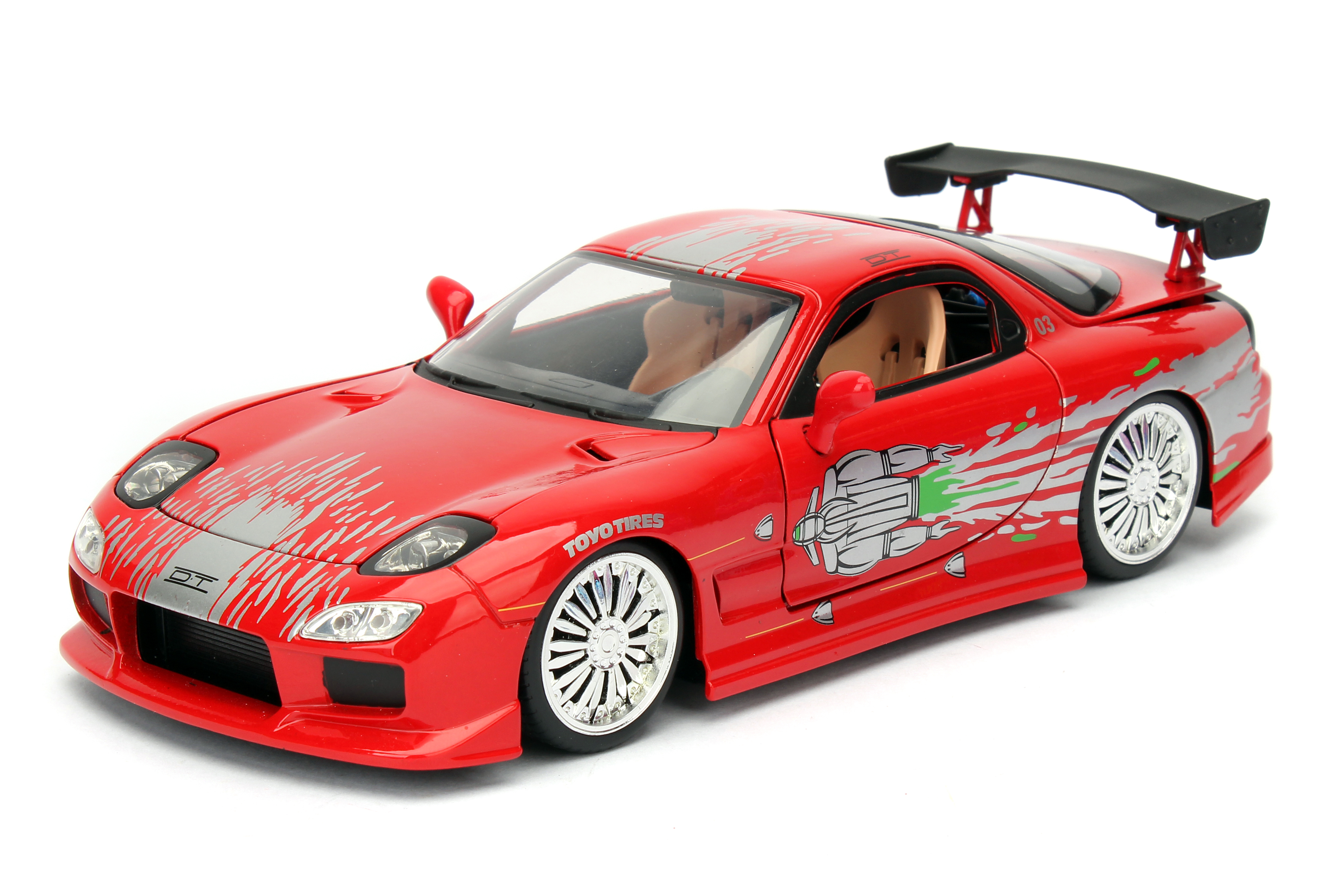 Ein rotes Spielzeugauto mit silbernen Akzenten, einem schwarzen Spoiler und Chromfelgen steht auf weißem Untergrund.