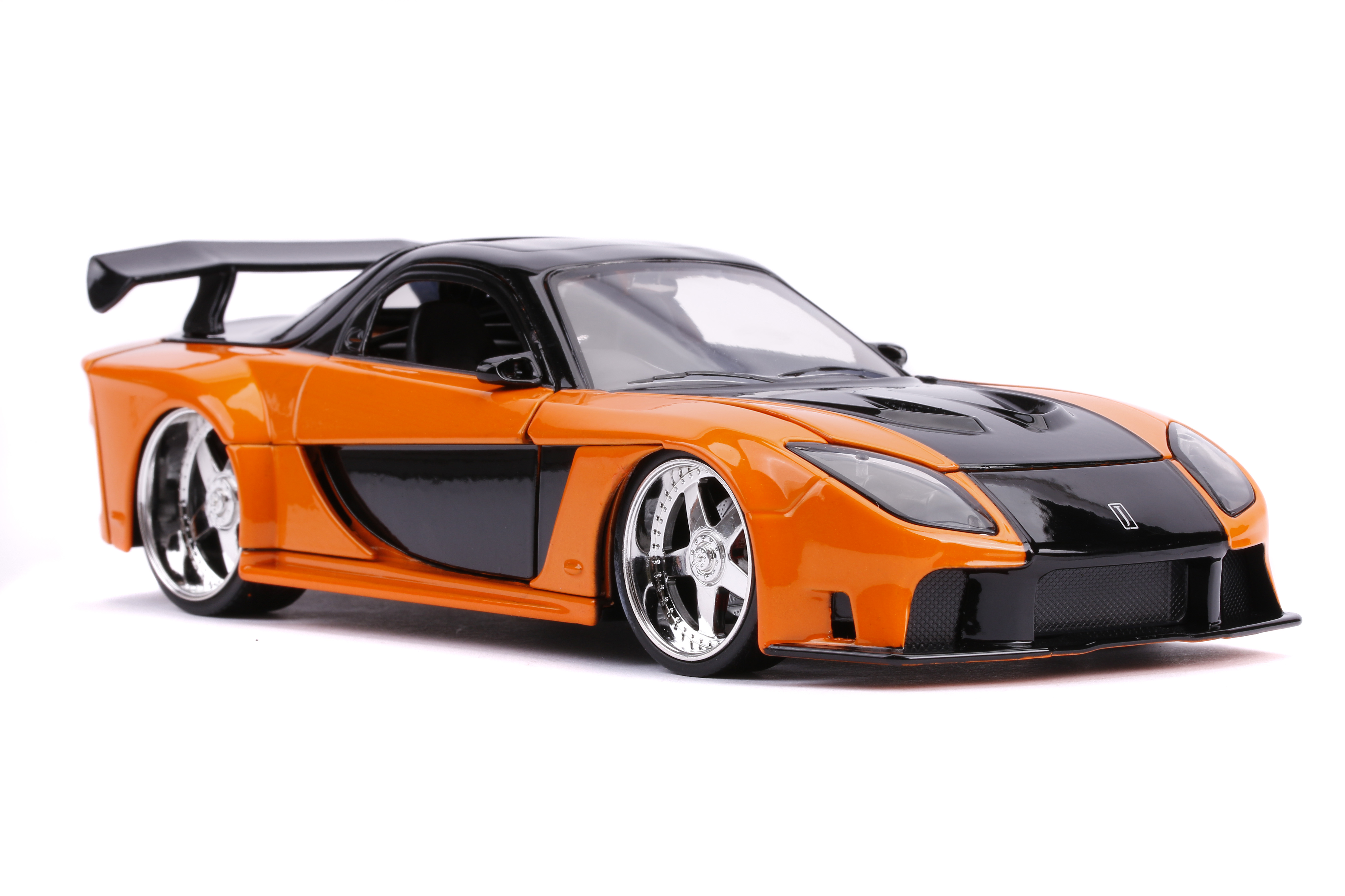 Oranges und schwarzes Spielzeugauto. Es hat einen Spoiler und Chromfelgen. Weißer Hintergrund.