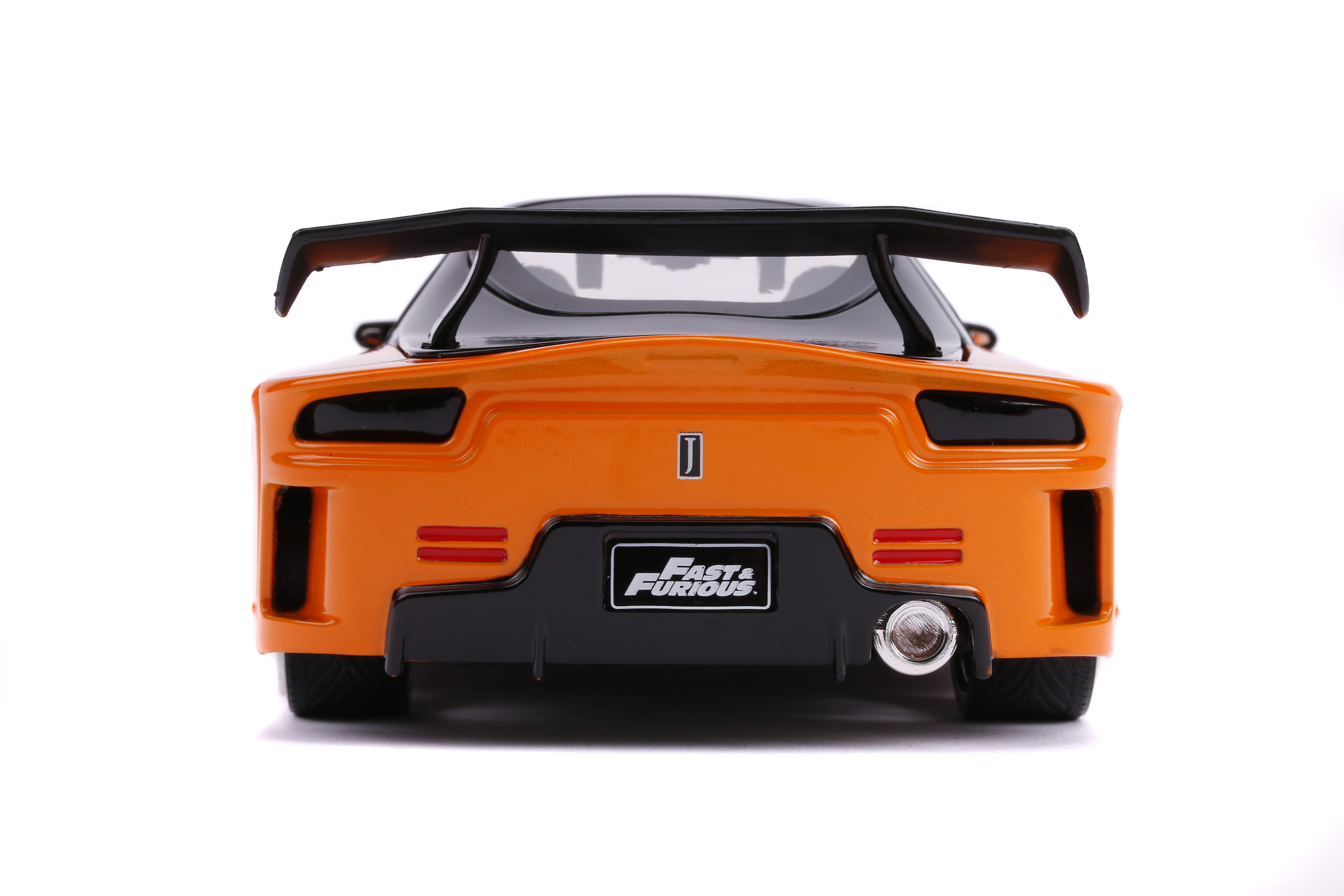 Rückansicht eines orangefarbenen Spielzeugautos mit schwarzem Spoiler. Das Auto hat das Fast & Furious-Logo.