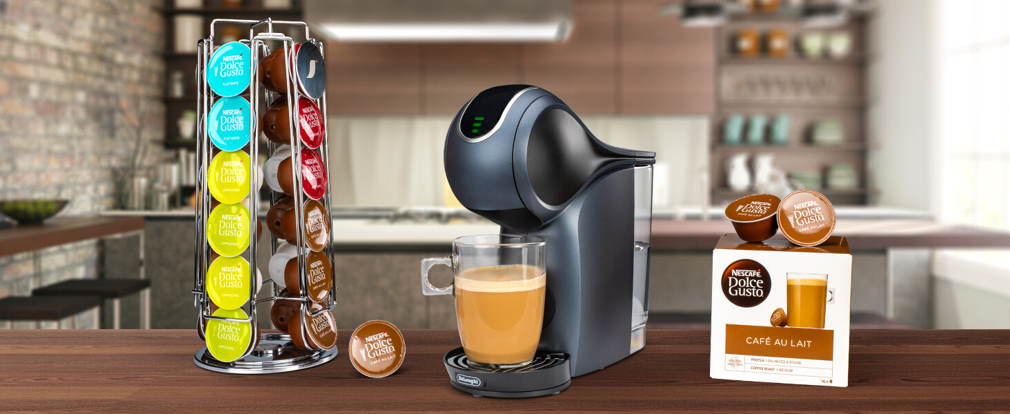 Máquina de café con una taza de café. Un estante de cápsulas de café y cápsulas de café delante.