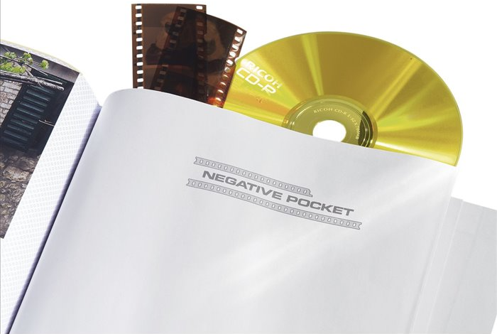 Fehér fotóalbum nyitva, filmszalagokkal és egy arany CD-vel egy negatív zsebben.