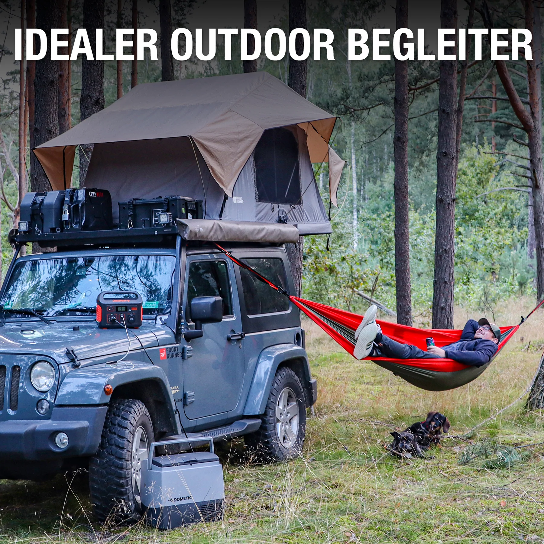 Jeep mit Dachzelt, Mann in Hängematte und Jackery Powerstation im Wald.