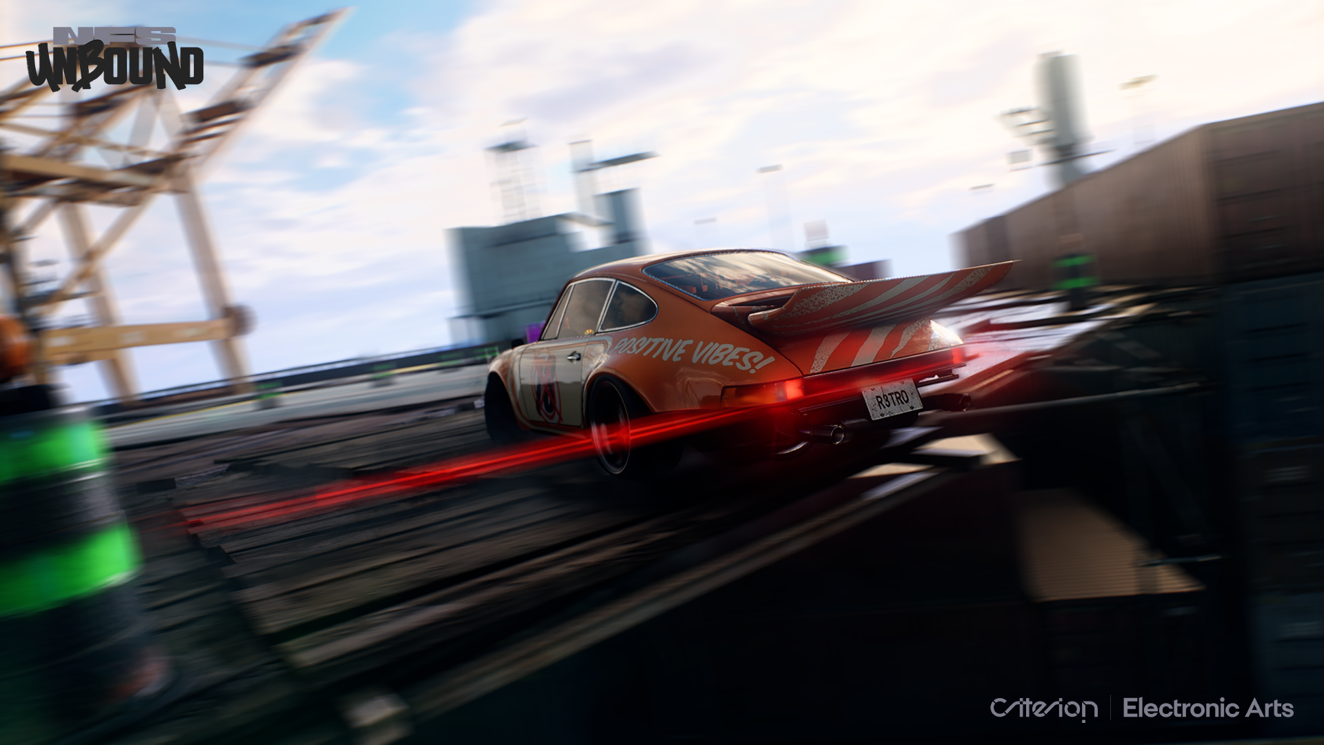 Porsche orange avec des rayures de course traverse un pont. Traînées de lumière rouge derrière. Les mots "POSITIVE VIBES!" sur le côté.