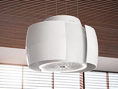 Eine weiße Dunstabzugshaube, die von der Decke hängt. Sie hat ein modernes Design und einen kreisförmigen Ventilator.