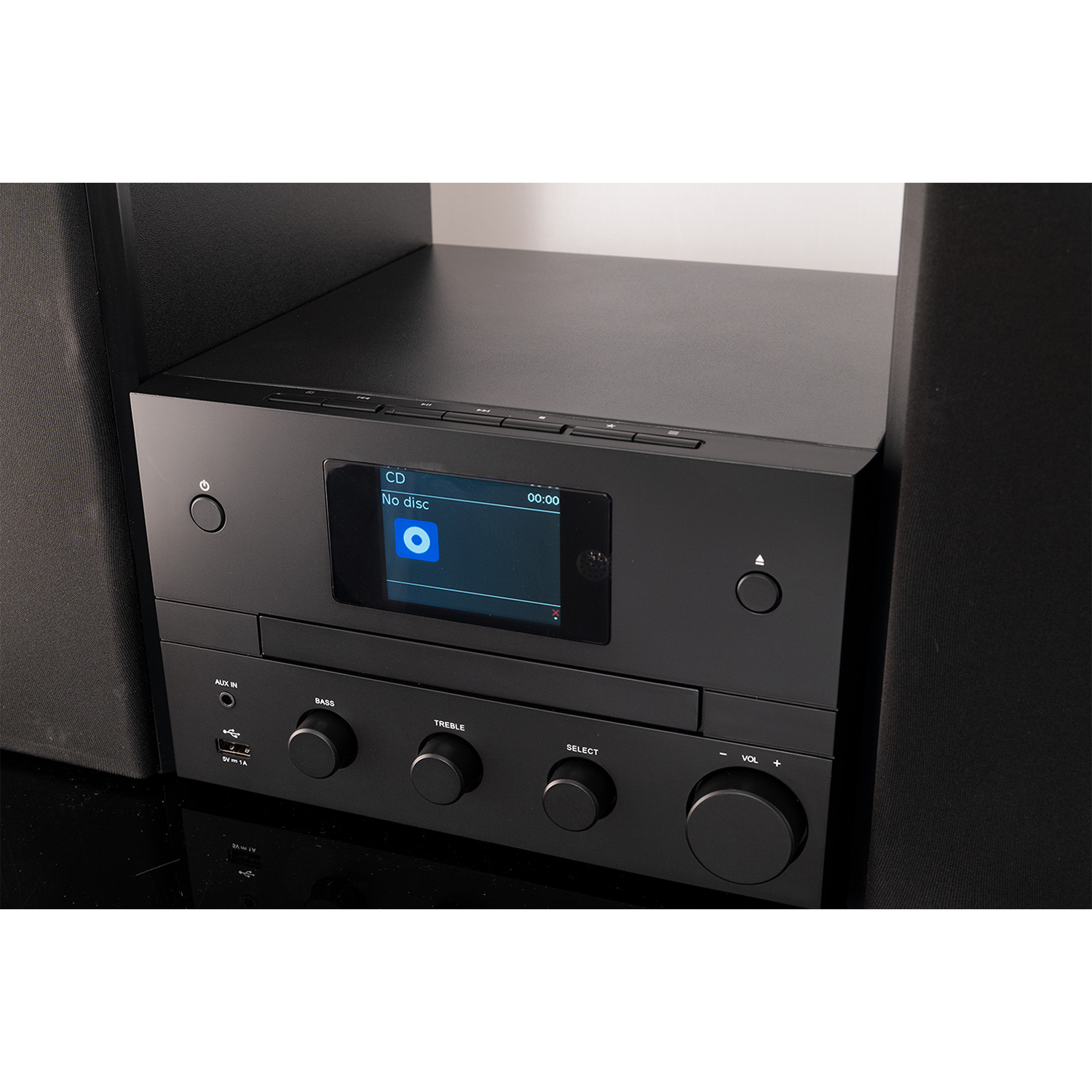 Impianto stereo nero con display CD, controlli bassi, alti e volume. Altoparlanti su entrambi i lati.