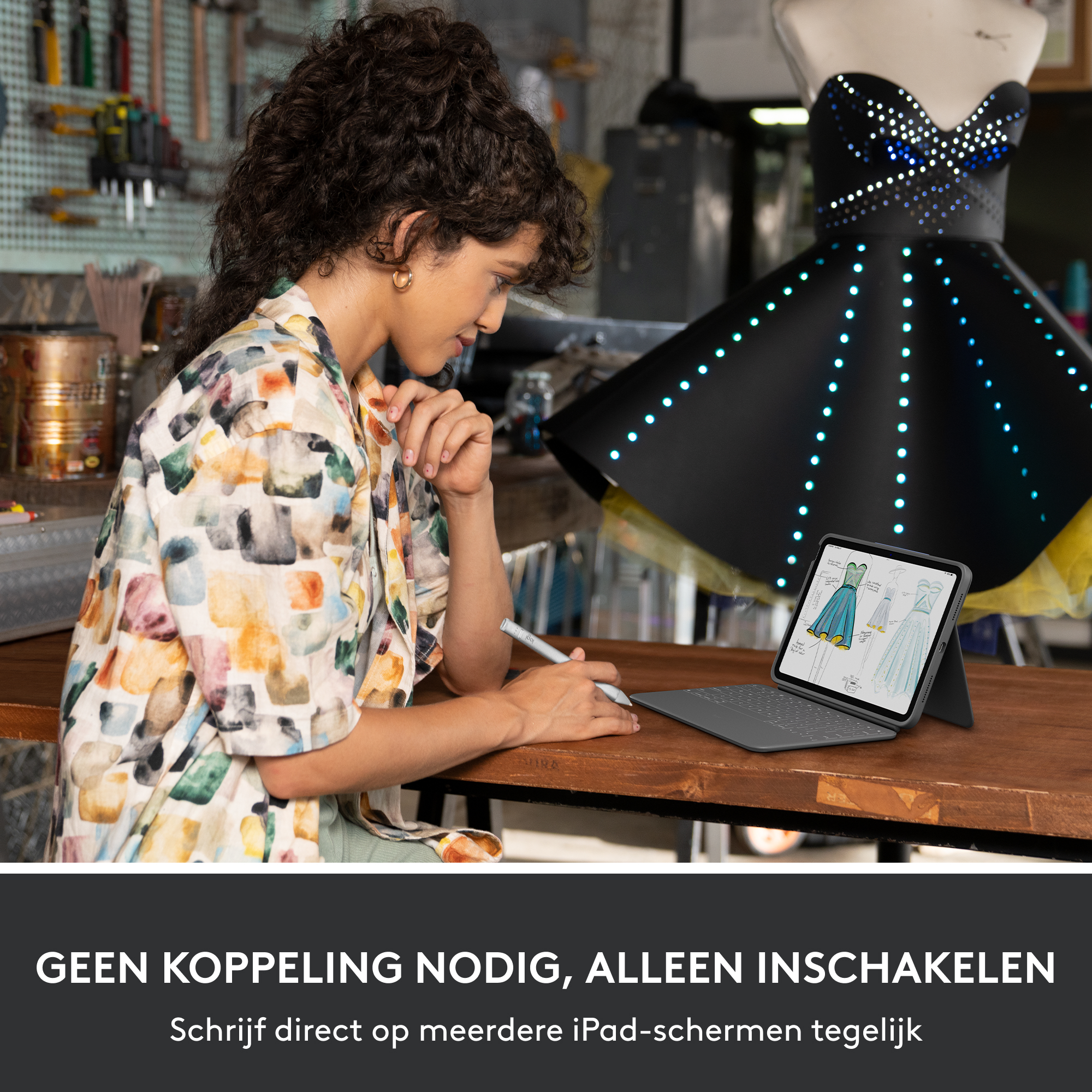 Woman using a tablet with a stylus pen. A dress form with a dress illuminated with lights is in the background.