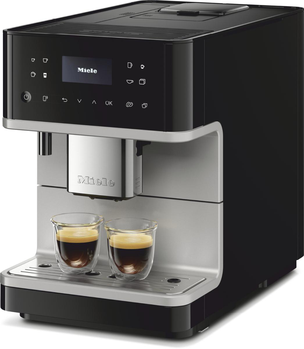 Eine schwarze und silberne Miele-Kaffeemaschine mit zwei Tassen Kaffee.