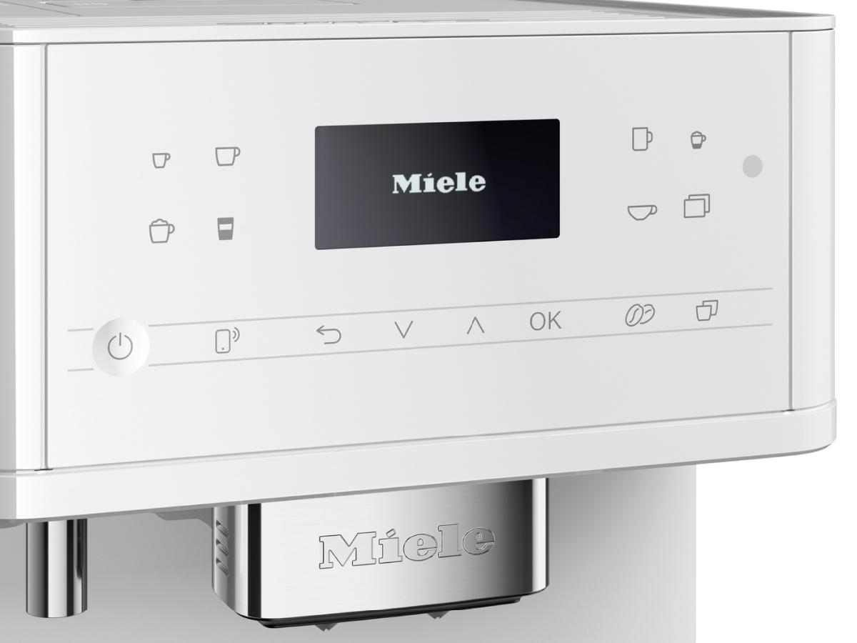 Weiße Kaffeemaschine mit Bildschirm und Knöpfen. 'Miele' wird angezeigt.