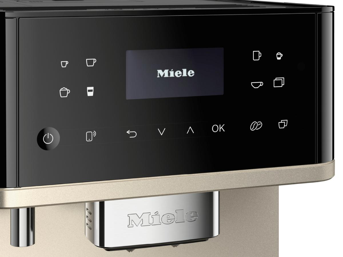 Schwarze und goldene Kaffeemaschine mit einem Bildschirm, der 'Miele' anzeigt.