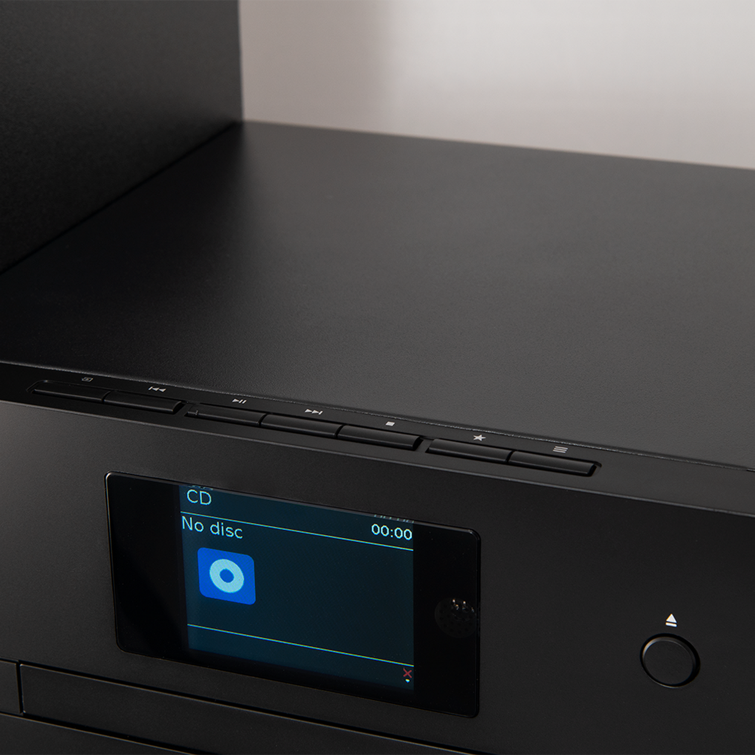 Black CD player, with the display on showing: CD, No disc, and time. Black background.