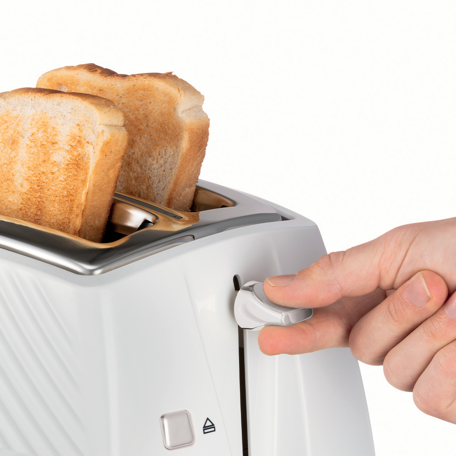 Hand is toasting bread in a white toaster. Two slices of bread are in the toaster.