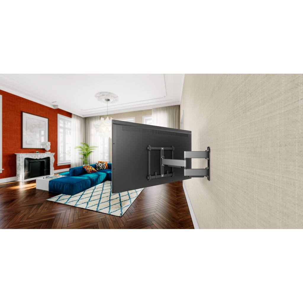 Un televisor grande montado en una pared con un soporte moderno, en un salón con un sofá azul.