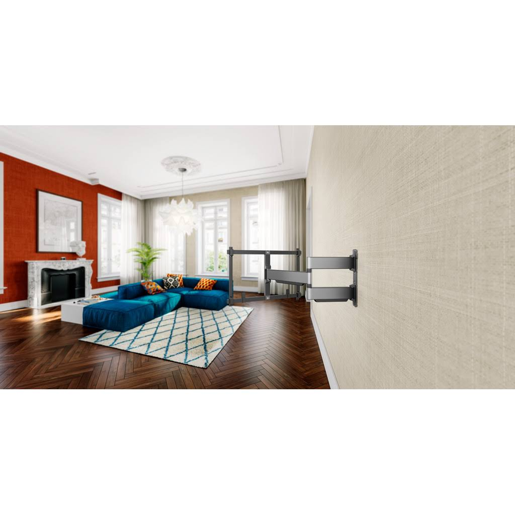 Salón moderno con sofá azul, alfombra y soporte de TV de pared.