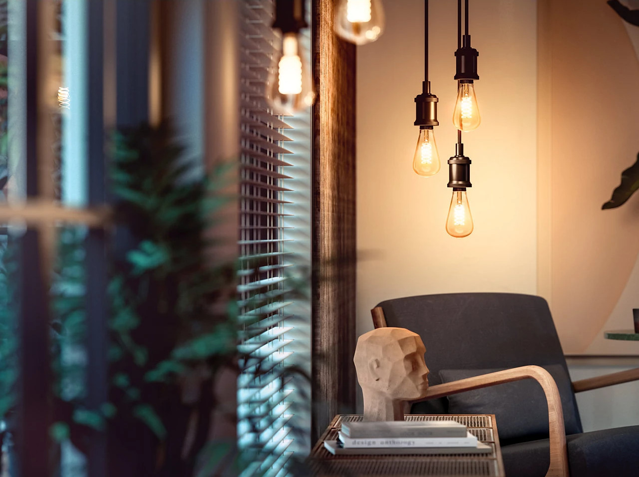Interior scene with hanging light bulbs, wooden head sculpture, and a dark armchair.
